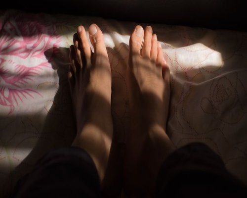 A person resting calmly on a comfortable bed with soft sunlight