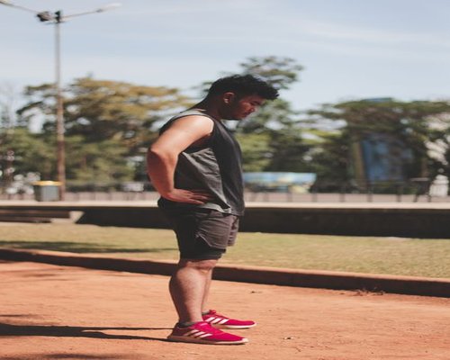 A person taking a short walking break in a sunny urban park in Indonesia