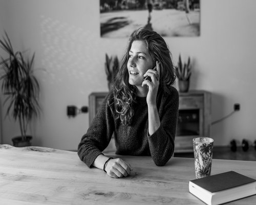 A professional receiving a phone call while standing in a home office