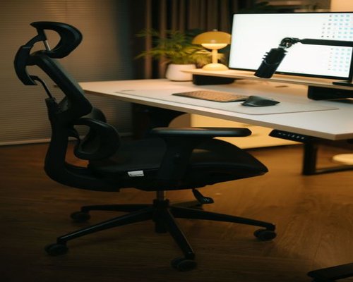 A professional individual adjusting posture while working comfortably at a modern home office desk in Indonesia