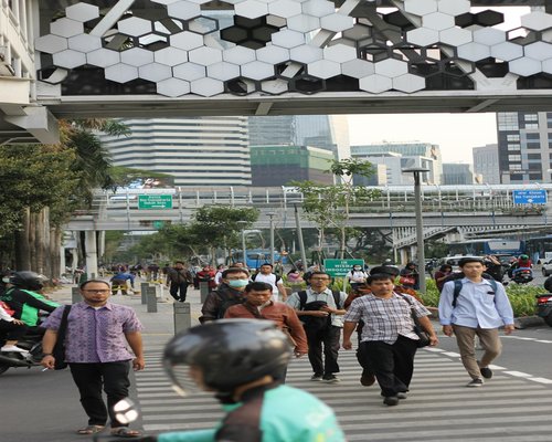 Commuters walking through a modern transit station in Jakarta